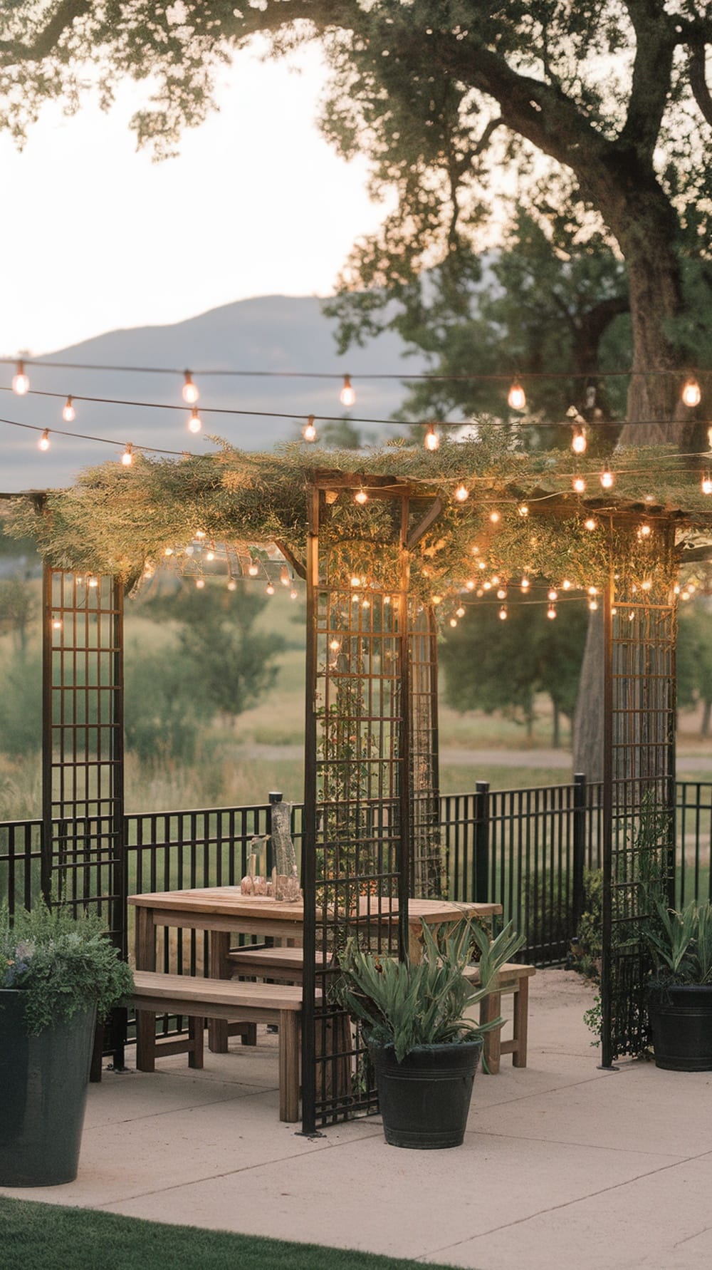 Cozy outdoor dining area with a trellis and string lights, surrounded by plants.